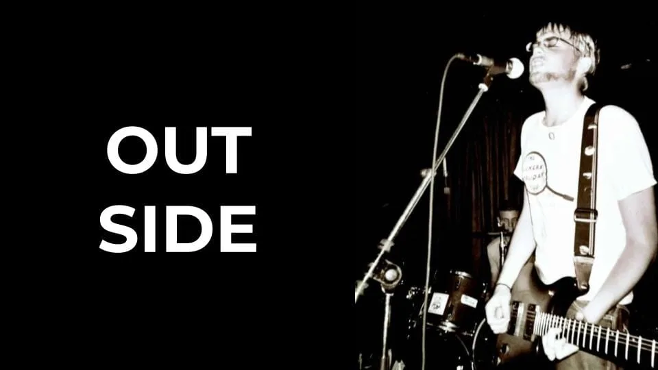 Featured image for Solarpunk: Life in the Future beyond the Rusted Chrome of Yestermorrow - a high-contrast black and white photo of a musician singing on stage beside the text OUT SIDE.
